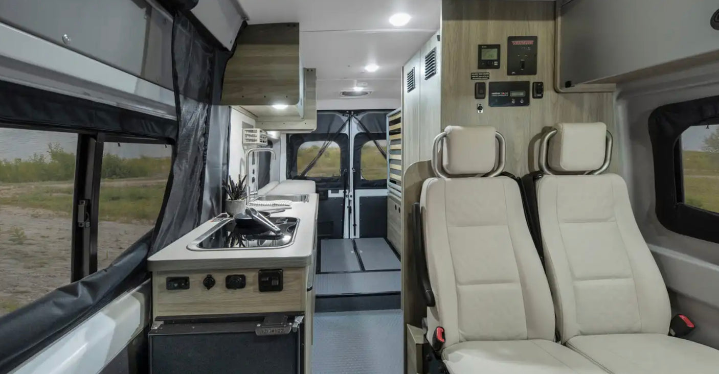 RV rental: Camper van interior featuring a modern kitchen, front seats, and a convertible rear living area.