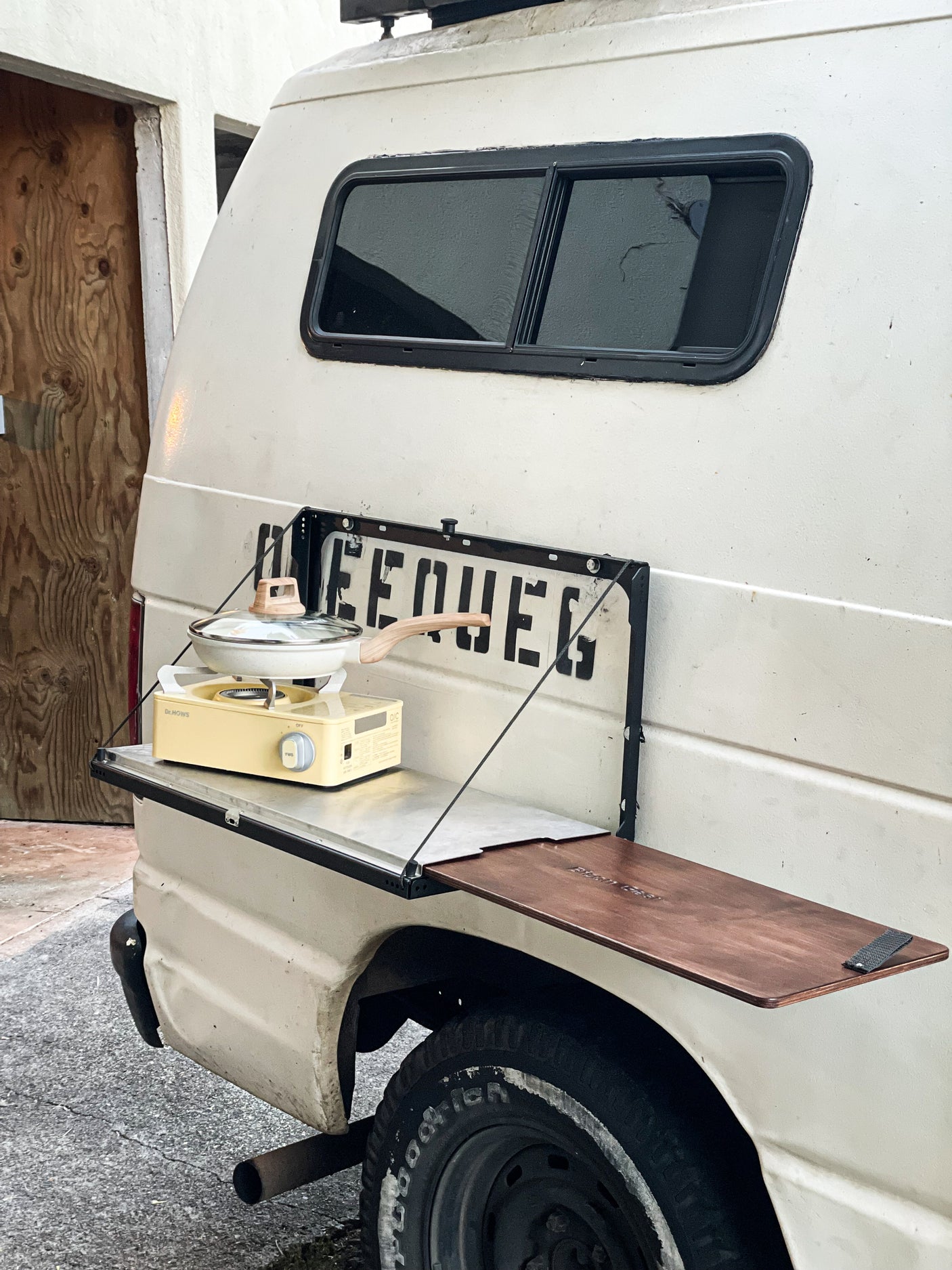 RV rental: Rear view of a van showing a portable stove on an attached table, ready for outdoor cooking.