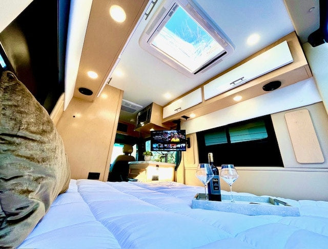 parked downtown by historic brick buildings including Rolland's Jewelers.|Enjoy your rv rental. This comfortable camper van interior