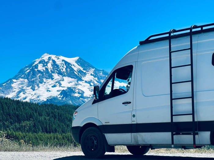 ideal for adventure travel.|This white rv rental van is parked on a dirt road