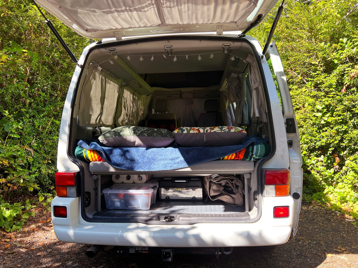 parked on a wooded trail under a sunny sky. Perfect for road trips!|Open rear hatch of an RV rental — photo 2