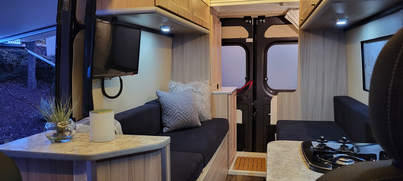 Cozy rv rental interior with modern kitchenette, comfy seating, TV, and rear doors. Perfect for adventures. — photo 13