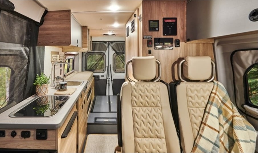 hinting at extra sleeping space. Perfect for your next RV rental and camping adventure!|Modern **RV rental** interior with full kitchen