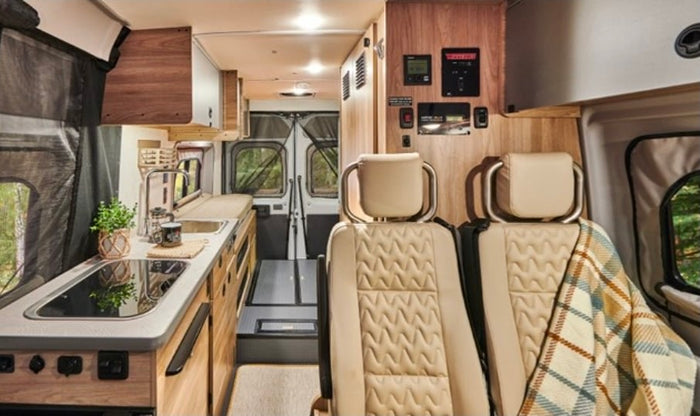 hinting at extra sleeping space. Perfect for your next RV rental and camping adventure!|Modern **RV rental** interior with full kitchen