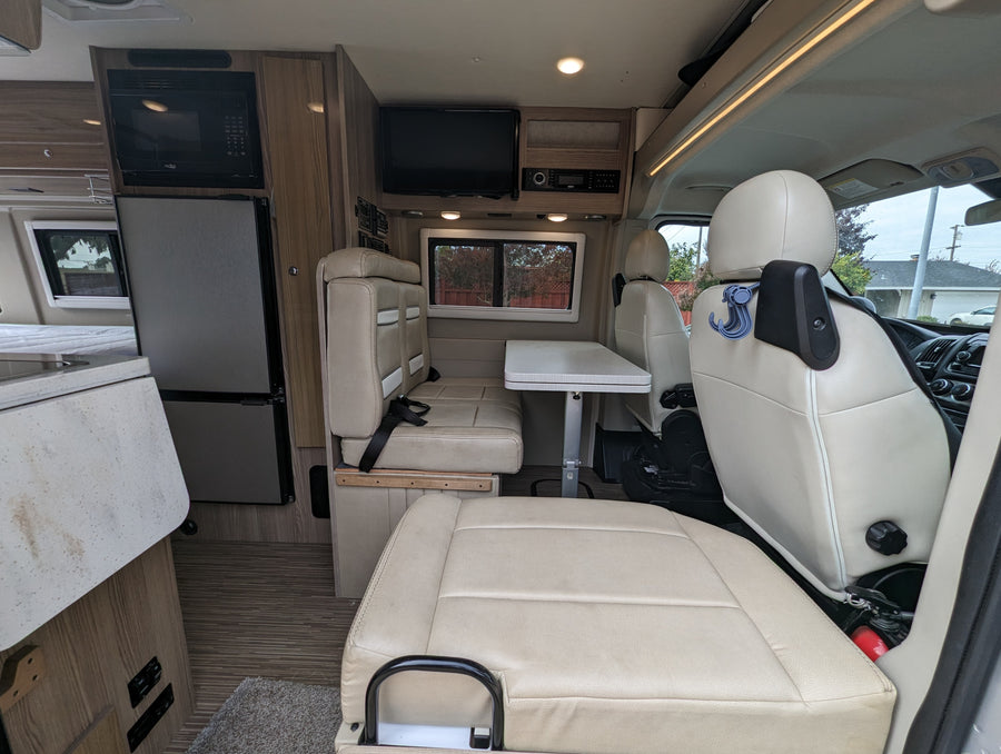 Explore this RV rental's cozy interior, featuring a kitchenette, dining area, and comfortable seating for your adventure.