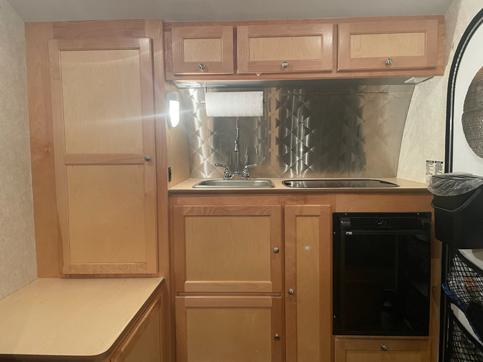 and a small kitchenette. Ideal for travelers.|RV rental kitchen: light wood counters