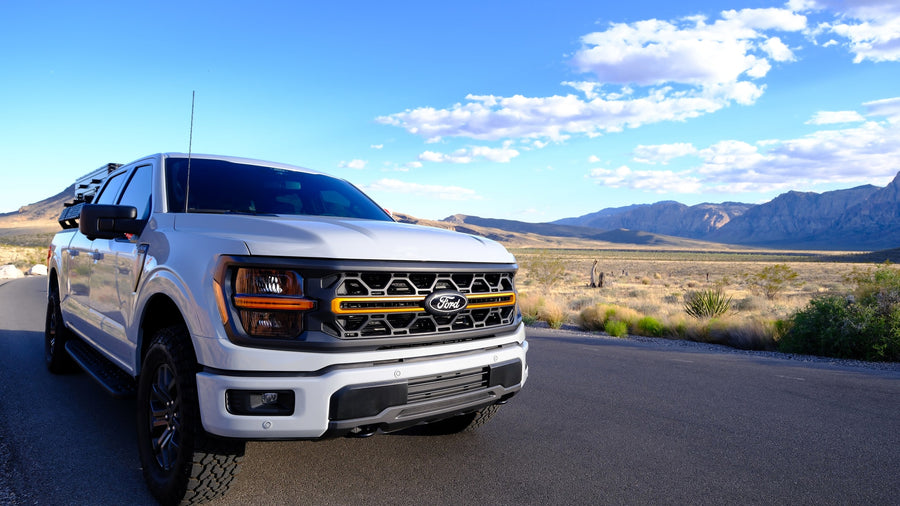 Explore scenic desert trails with this rugged Ford F-150 Tremor pickup, ideal for adventure rv rental. Mountains in background.