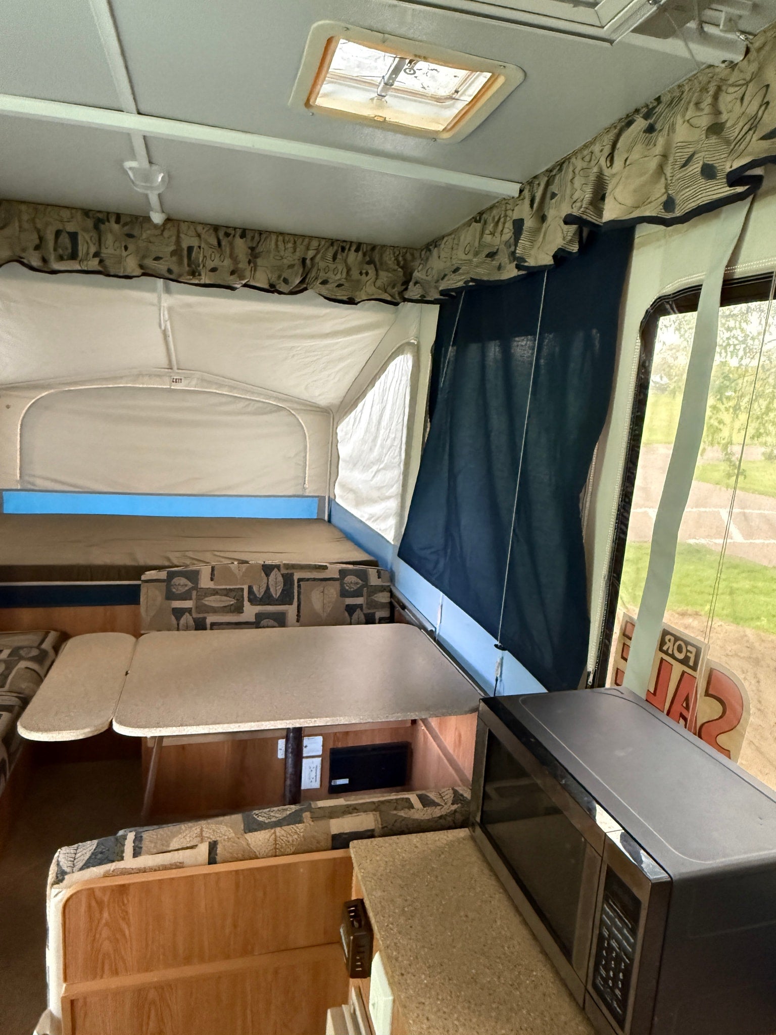 perfect for a campout.|Experience a cozy RV rental pop-up camper interior with beds