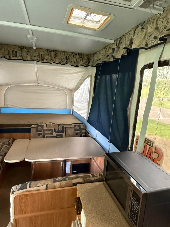 perfect for a campout.|Experience a cozy RV rental pop-up camper interior with beds