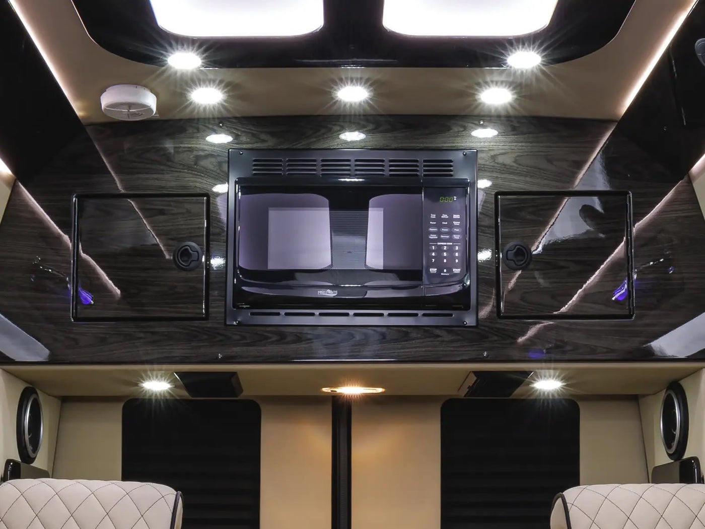 and an "Ultimate Toys" entertainment display.|Luxurious RV rental interior: custom beige seating — photo 11