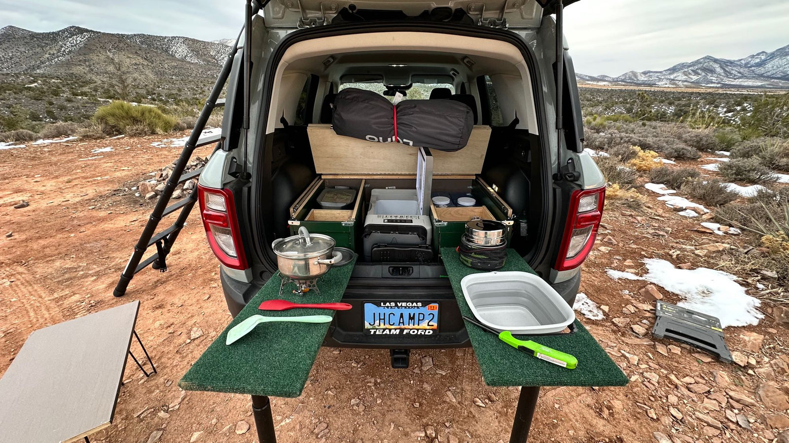 offering snowy mountain views & sunset.|SUV transformed into an overlanding kitchen with custom storage in snowy mountains. Explore adventure car camping