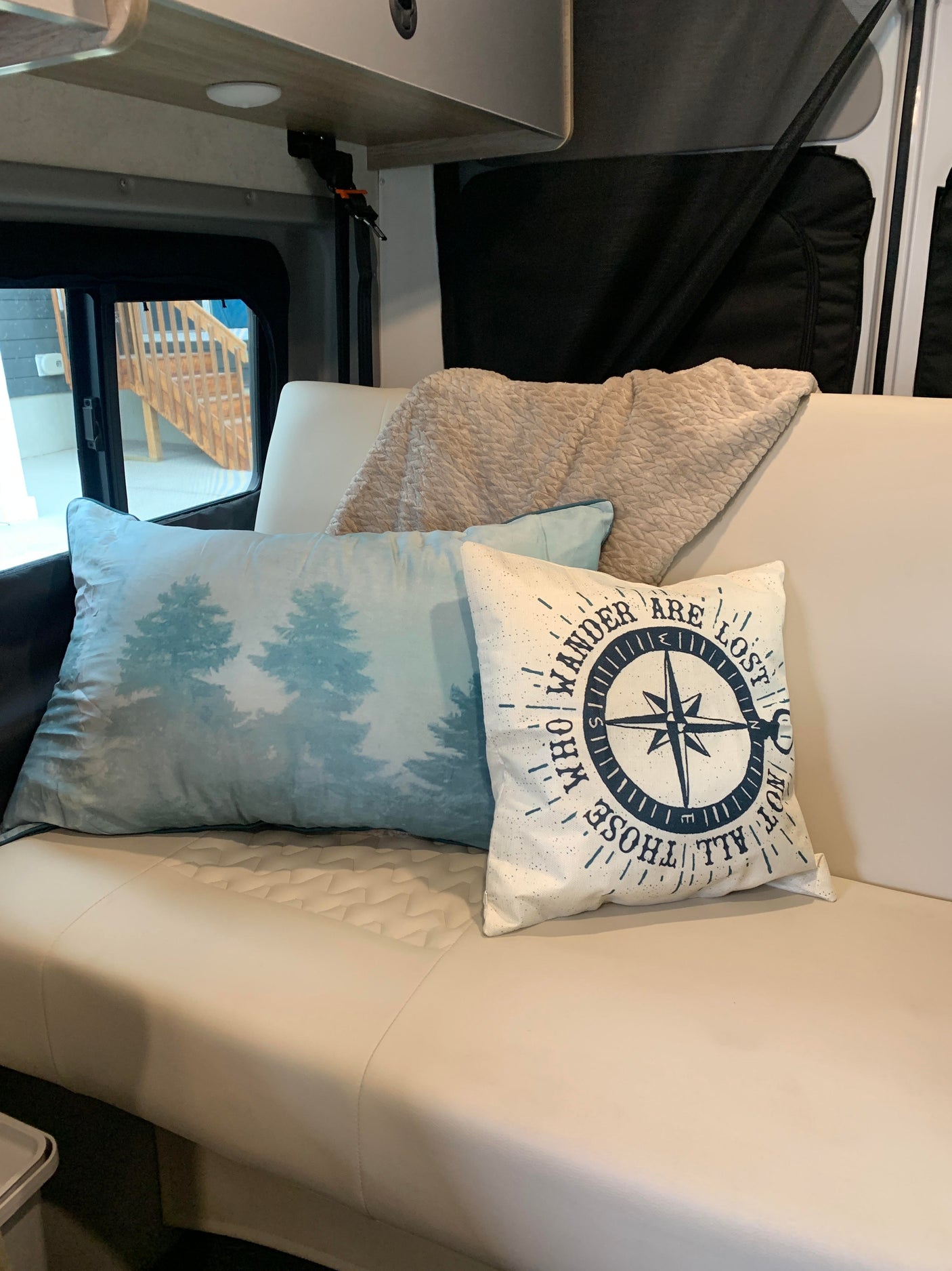 Cozy RV rental interior with pillows and blanket on a comfortable sofa, perfect for your next adventure.