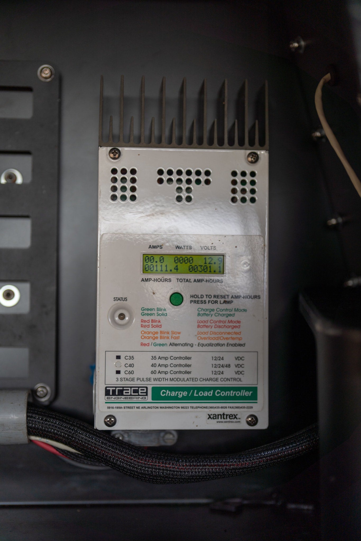Charge controller in an RV rental displaying electrical stats like volts and amp-hours.