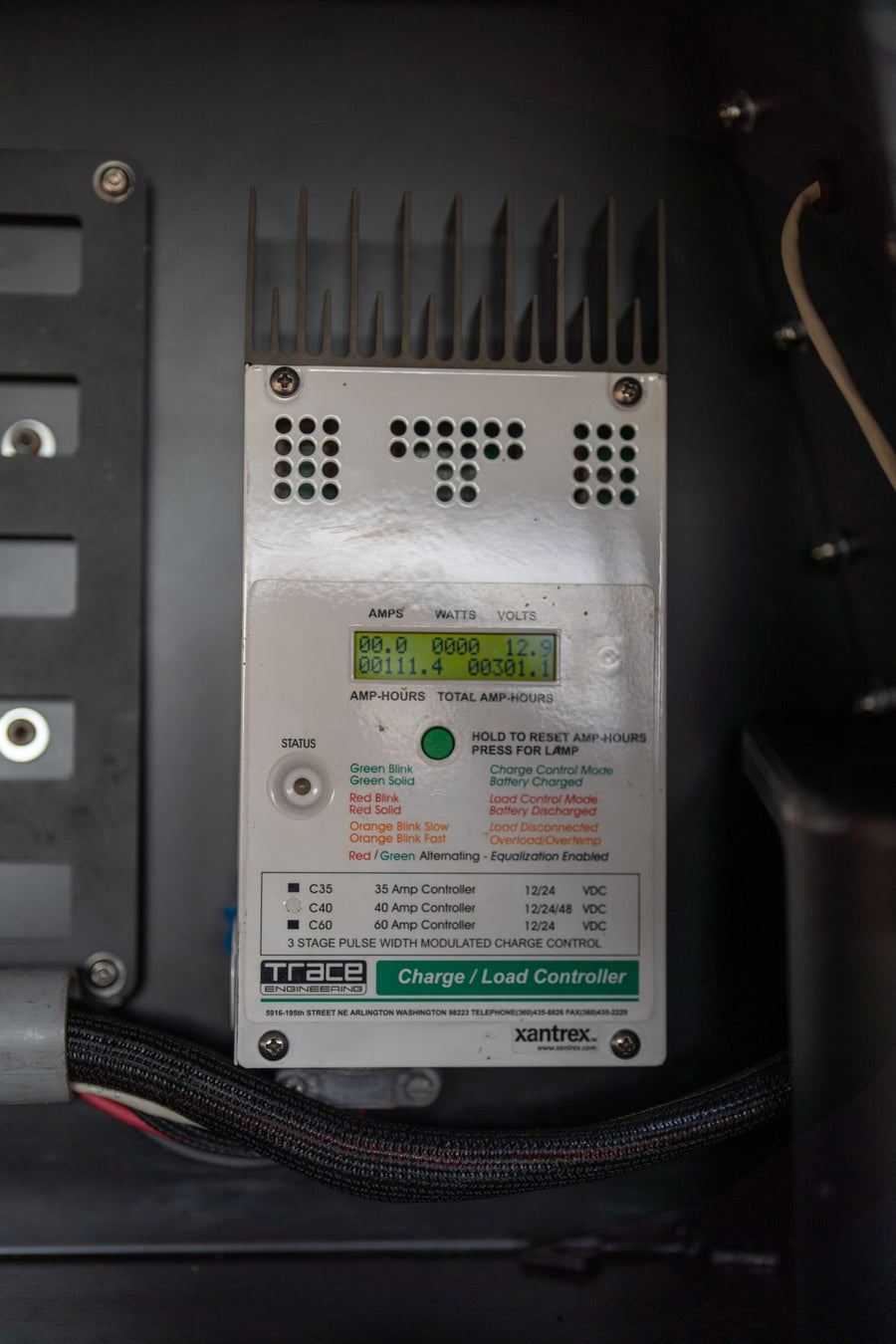 Charge controller in an RV rental displaying electrical stats like volts and amp-hours.