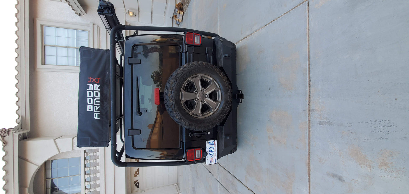Rear view of a black Jeep Wrangler, equipped with adventure gear. Great for camping and exploring, an RV rental alternative.