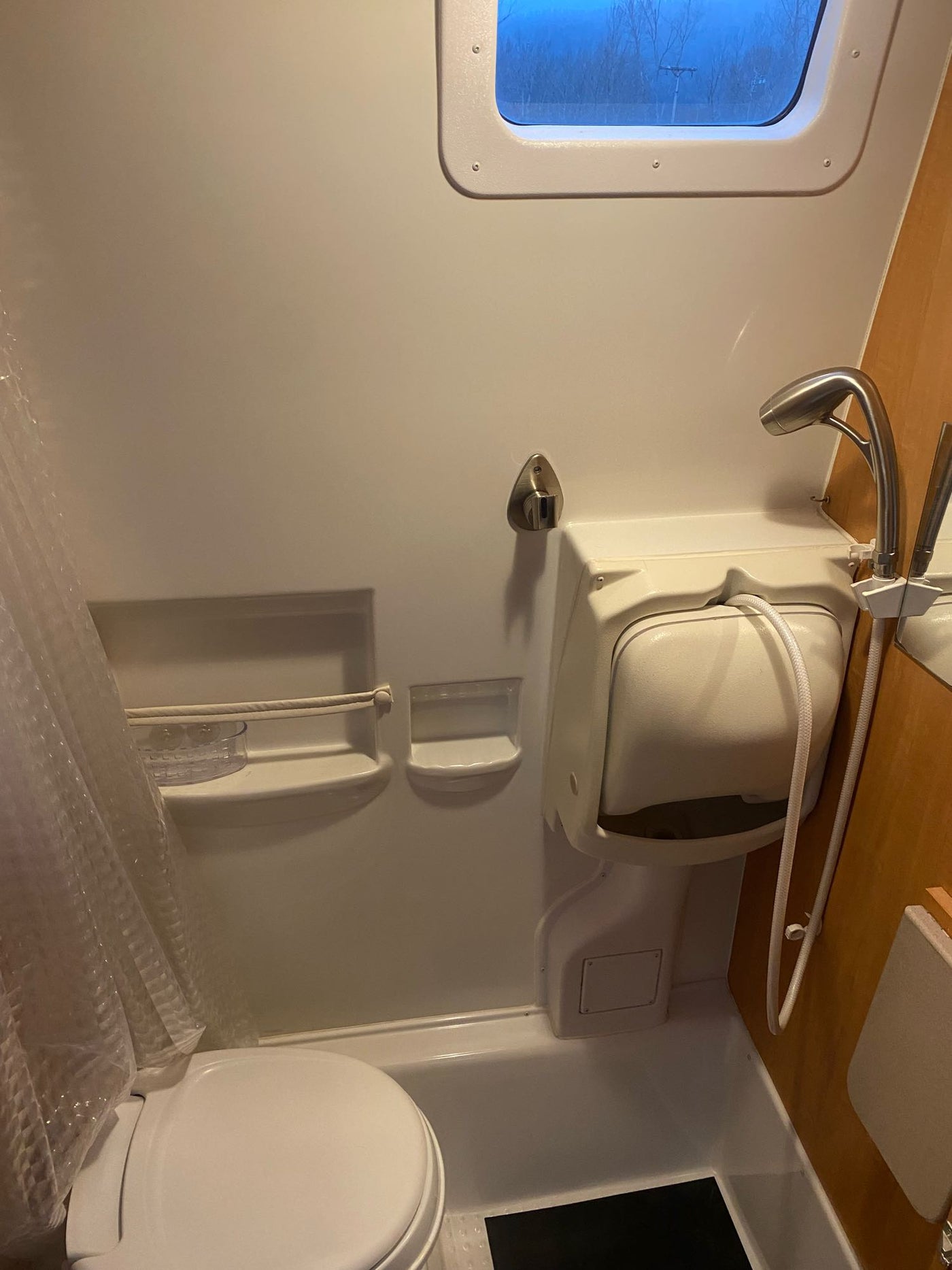 and large windows revealing parked cars outside.|Cozy RV rental interior: Full view from rear — photo 9