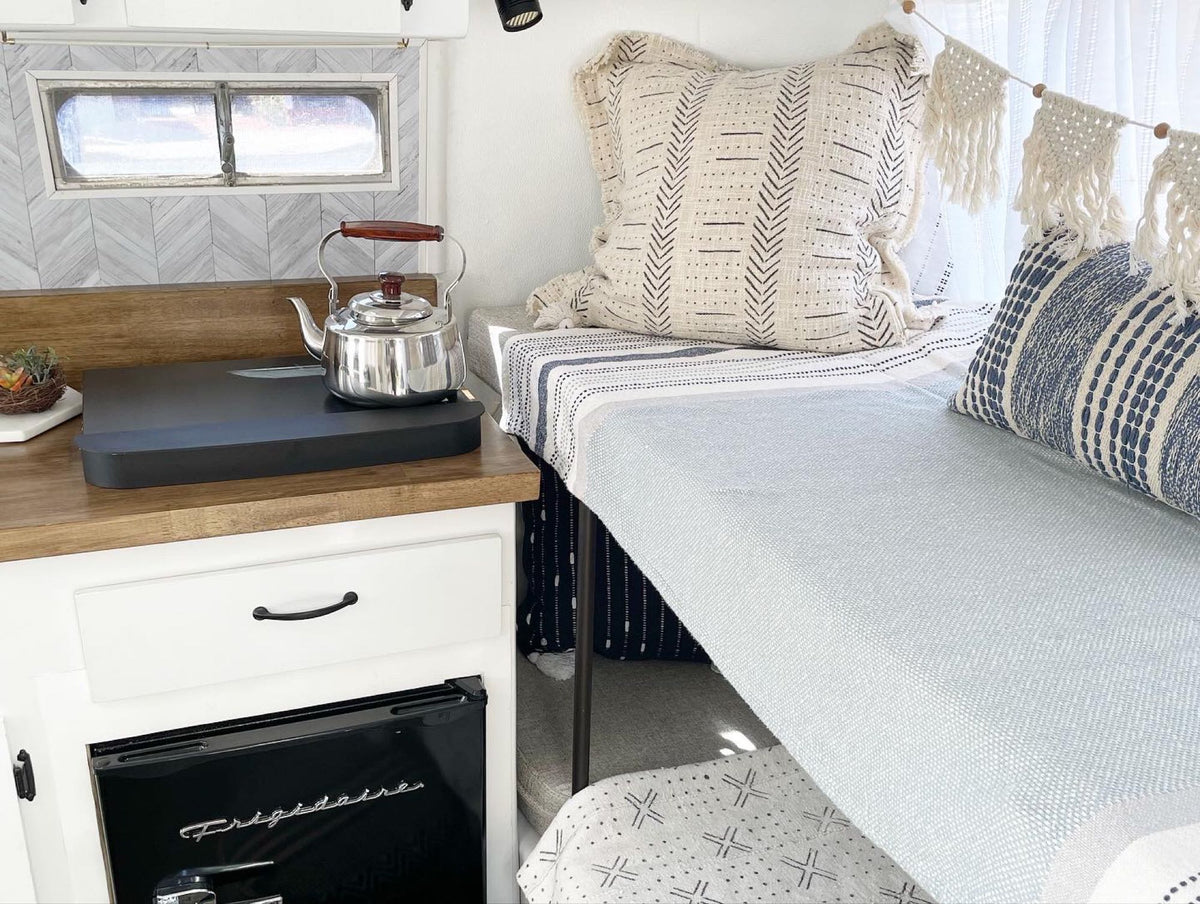plus a cozy dining booth.|Stylish RV rental interior: bunk beds with boho decor — photo 5