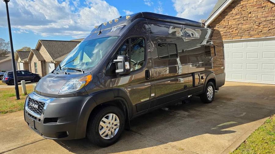 with its pop-top roof raised and side door open. Ready for your next adventure.|This sleek dark grey Ram ProMaster camper van is a perfect rv rental