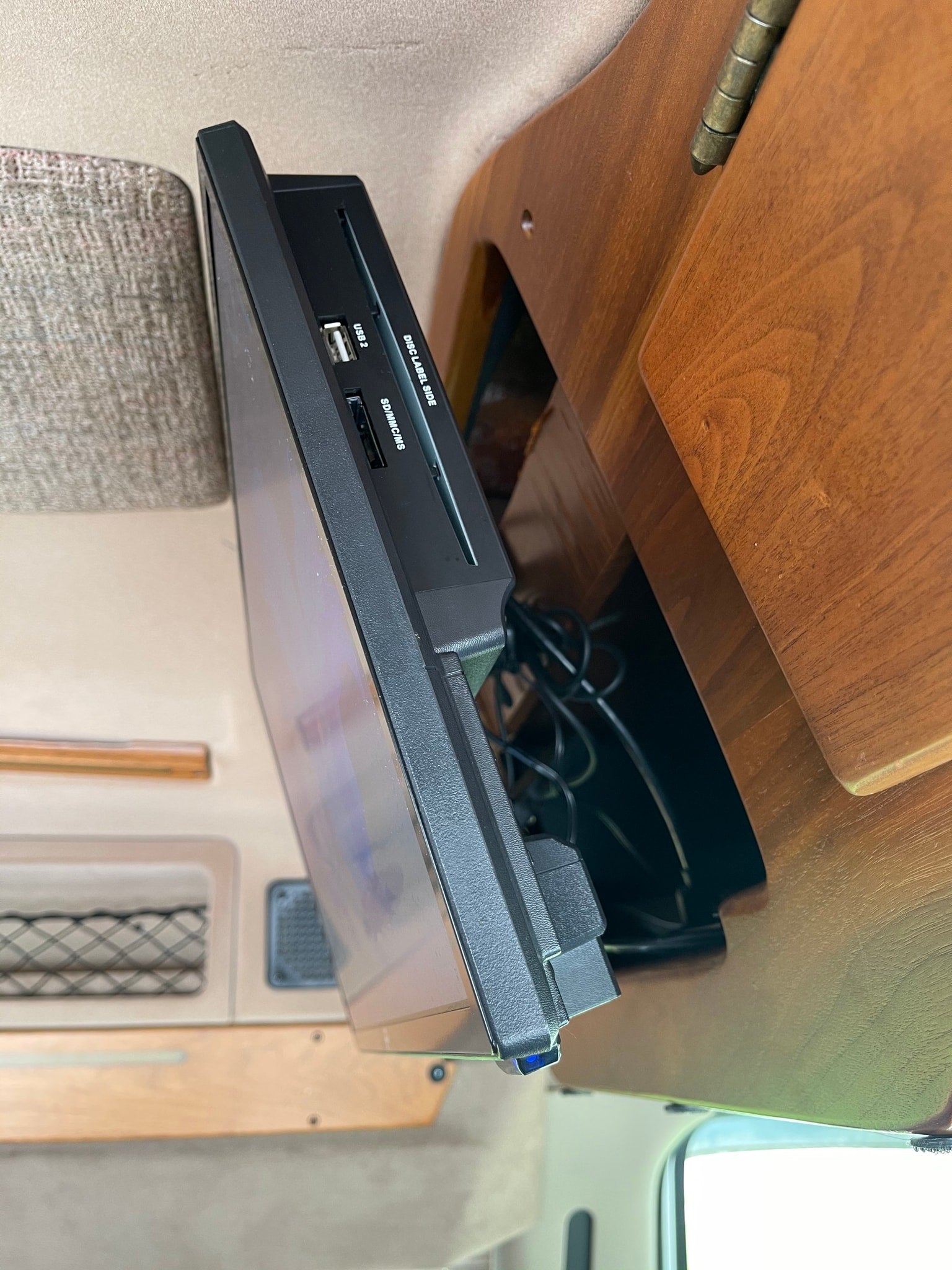 perfect for an RV rental. Parked curbside on a rainy day.|Side view of an RV rental entertainment system: a mounted media player with USB