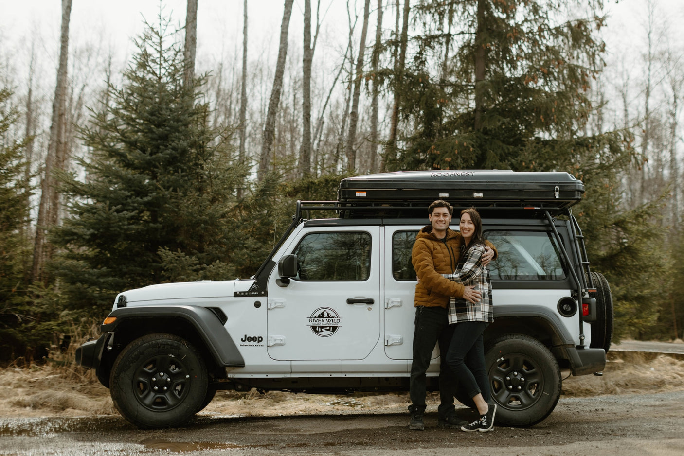 Happy couple with their River Wild Alaska Camper-Vans Jeep Wrangler RV rental and rooftop tent.|Scenic Alaska RV rental: White Jeep Wrangler with rooftop tent