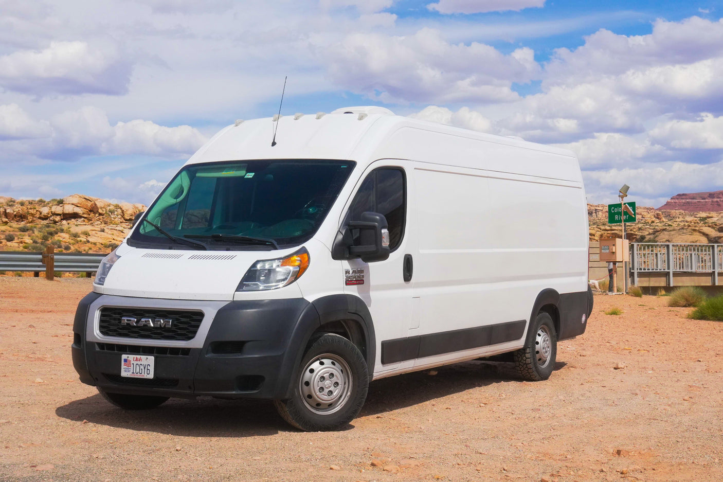 White Ram ProMaster RV rental van in Utah desert. This camper van is ready for adventures amidst rocky terrain under blue skies.