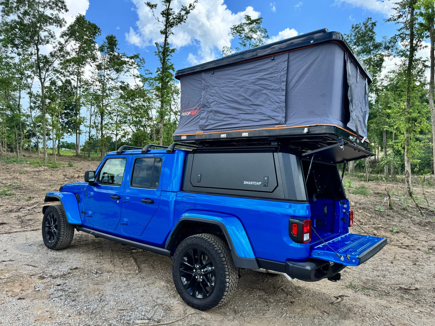 ideal for an RV rental or overlanding trip.|Blue Jeep Gladiator with Roofnest rooftop tent & SmartCap camper setup. Perfect for your next RV rental adventure.|Blue Jeep Gladiator with rooftop tent & bed cap for your next RV rental adventure.|This bright blue Jeep Gladiator — photo 7