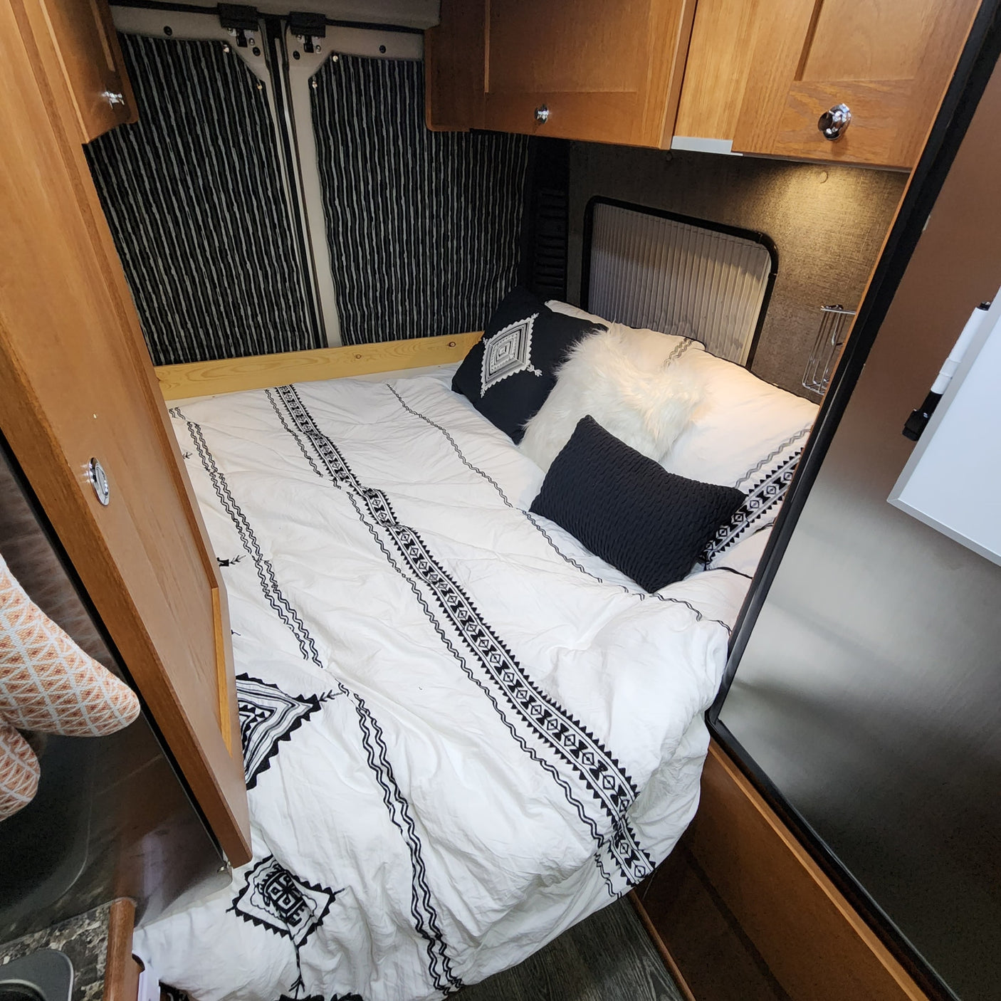 and a welcoming 'hello' mat at the door.|Cozy RV rental interior with a well-equipped kitchen