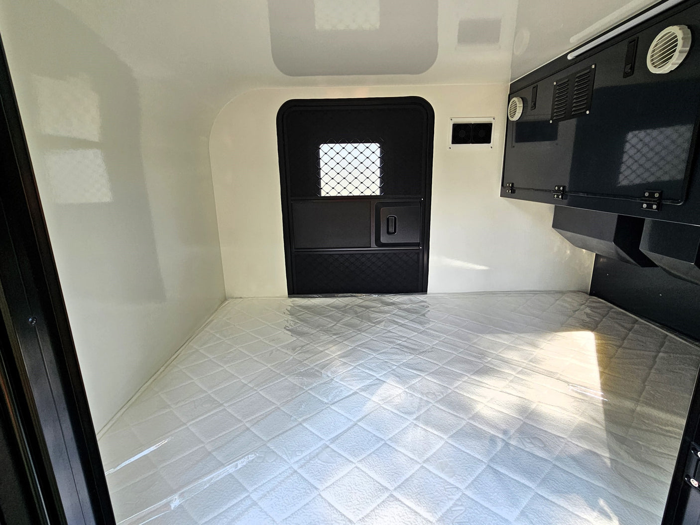 showcasing its simple interior. Ideal for an RV rental adventure.|Clean RV rental interior featuring a cozy mattress and compact sleeping area