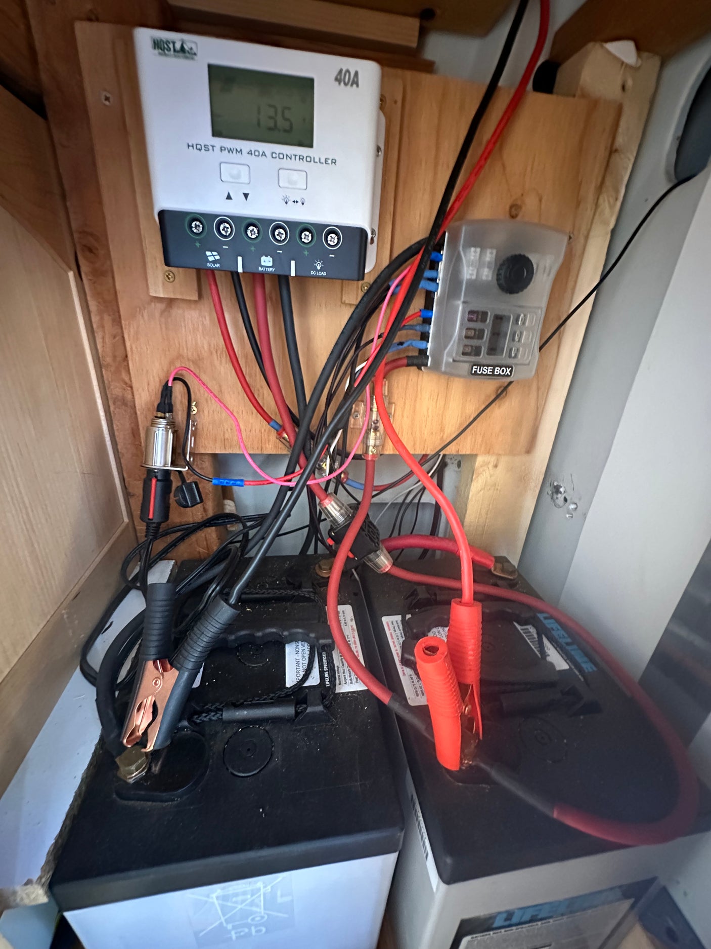 RV rental power system: Solar charge controller (13.5V), fuse box, and two Lifeline batteries, showing wiring setup.