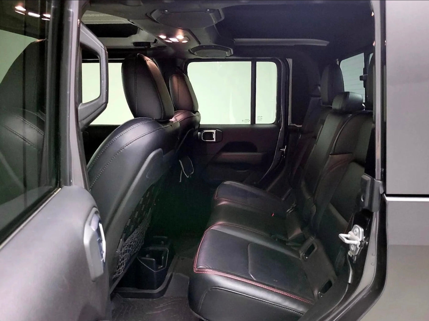Inside view of a roomy vehicle, potentially for an rv rental. Shows black rear seats, overhead lights, and door details.