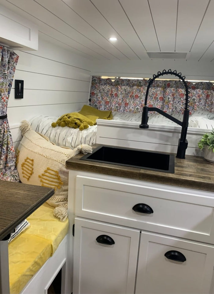 and white shiplap walls.|This cozy RV rental showcases a modern kitchen