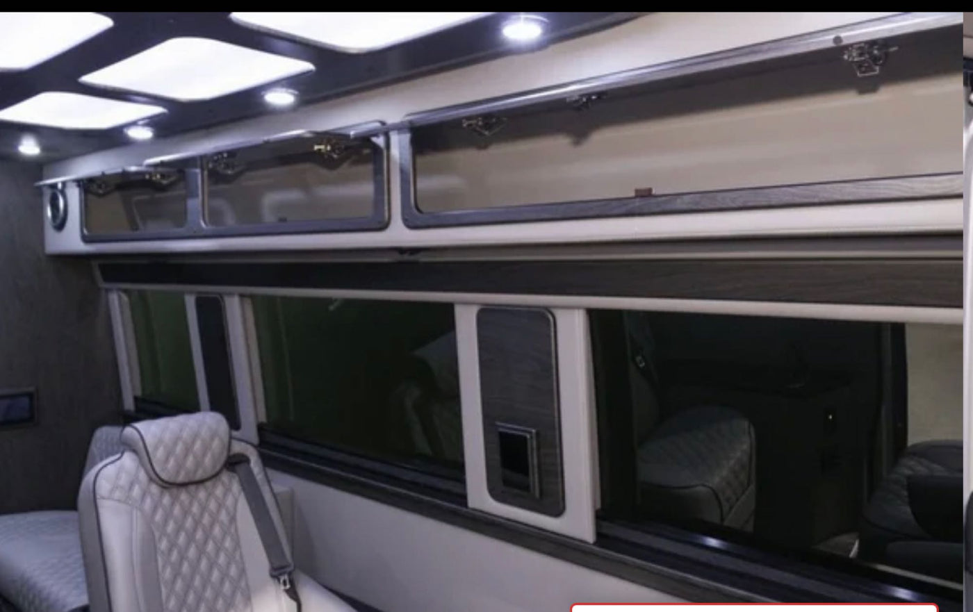 Experience luxury in this RV rental interior: bright overhead lights, glass-front cabinets, and quilted seating for comfort. — photo 9