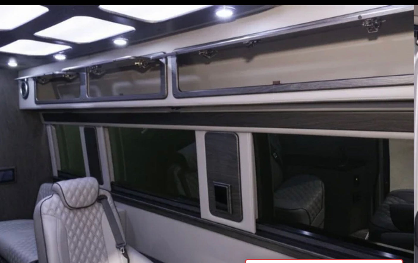 Experience luxury in this RV rental interior: bright overhead lights, glass-front cabinets, and quilted seating for comfort.