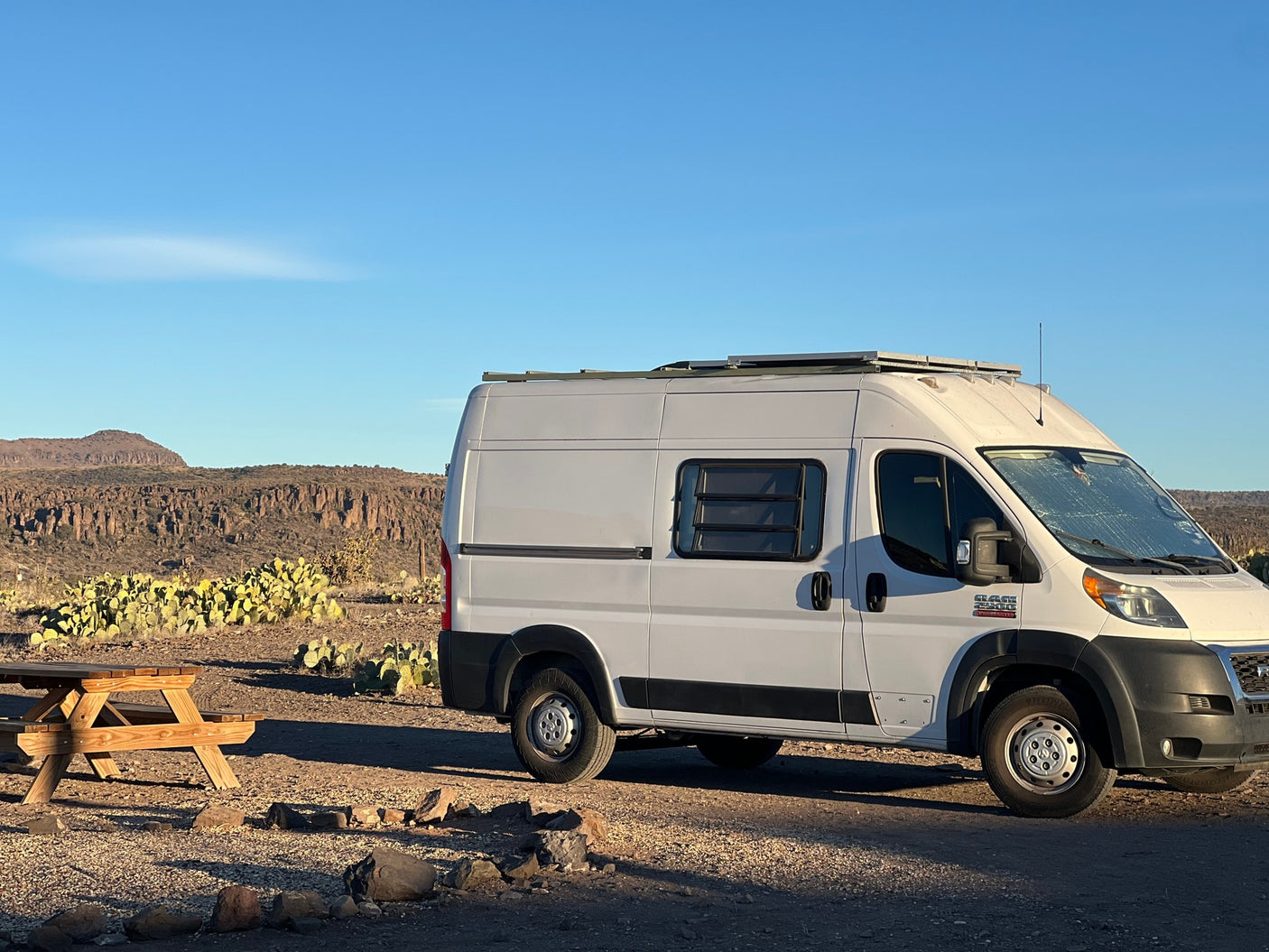 White RV rental camper van at a desert campsite