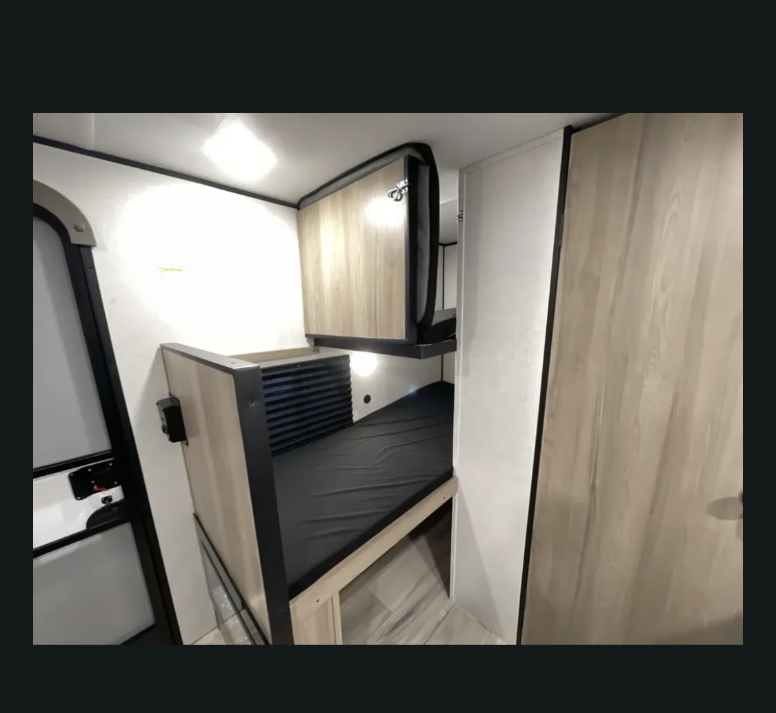 and light walls for comfortable travels.|Compact RV rental kitchen showing black microwave