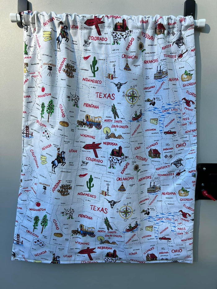 A vibrant fabric curtain displaying an illustrated US map with states & landmarks, a charming addition for an RV rental.