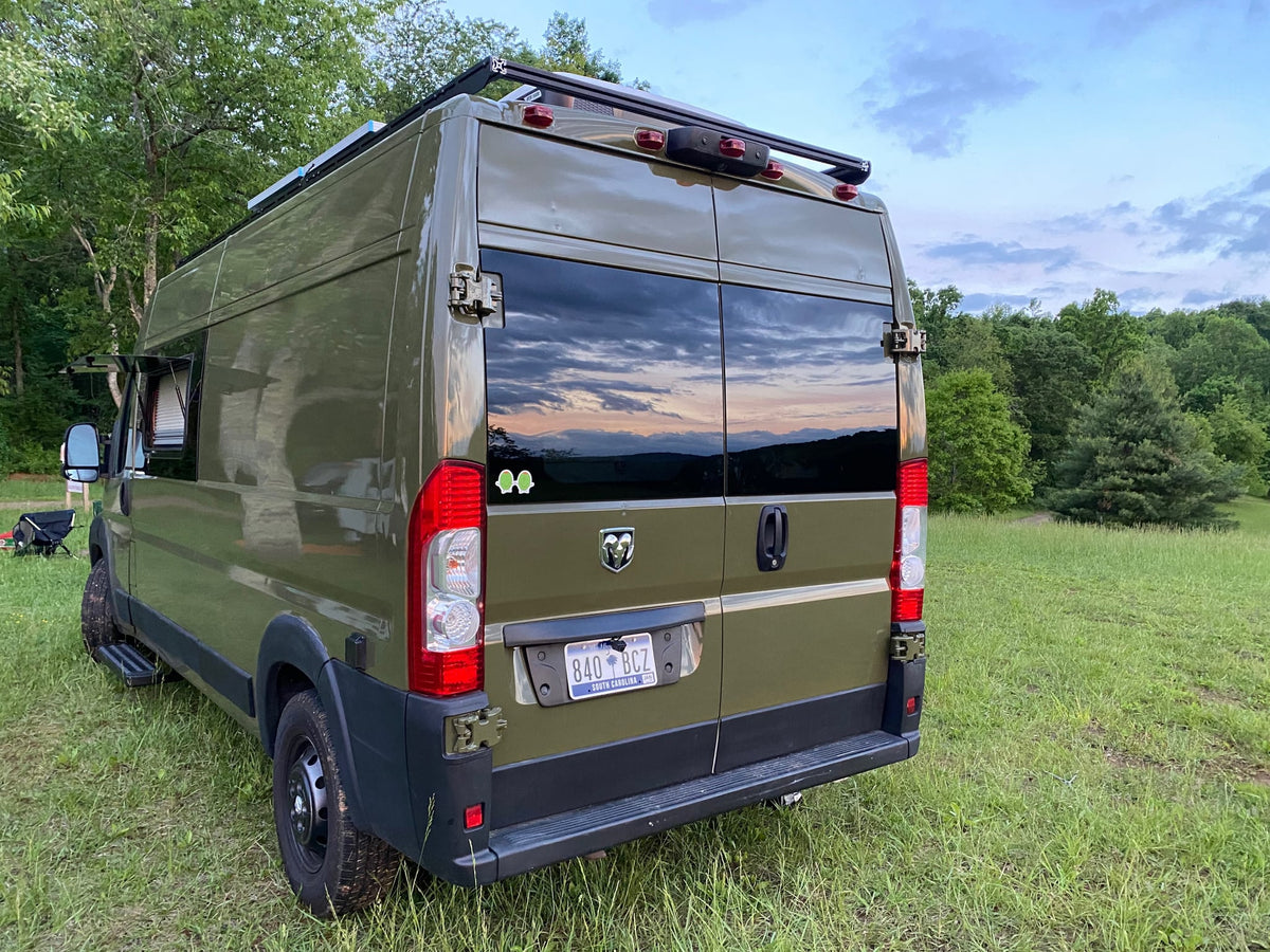 door open with a mat. Perfect for outdoor adventure & road trips.|This olive green customized camper van — photo 2