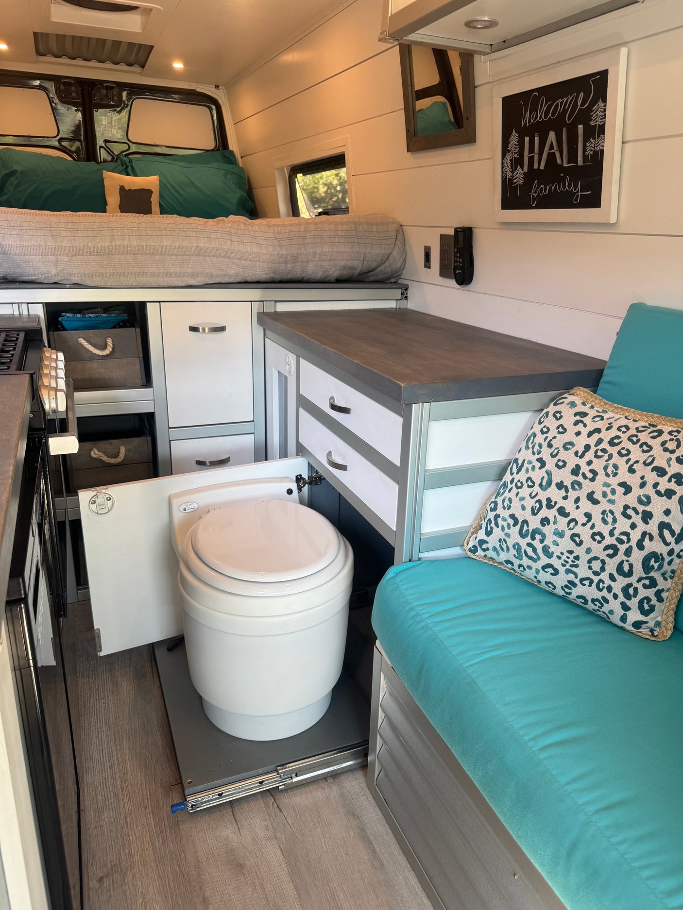 RV rental's clever interior: back bed, kitchen/storage, a pull-out toilet, and comfy side seating.