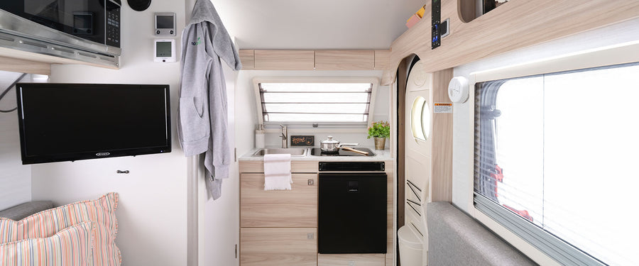 and an open book. Ideal for trips.|An rv rental's cozy grey U-shaped dinette