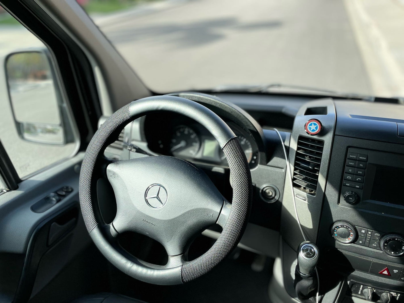 RV rental interior: Mercedes-Benz steering wheel, dashboard, and a Captain America shield emblem.