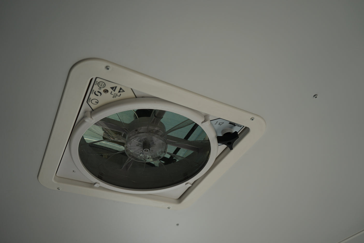 White RV rental ceiling fan with mesh screen, featuring auto, mode, on/off, and lid open/close controls for ventilation.