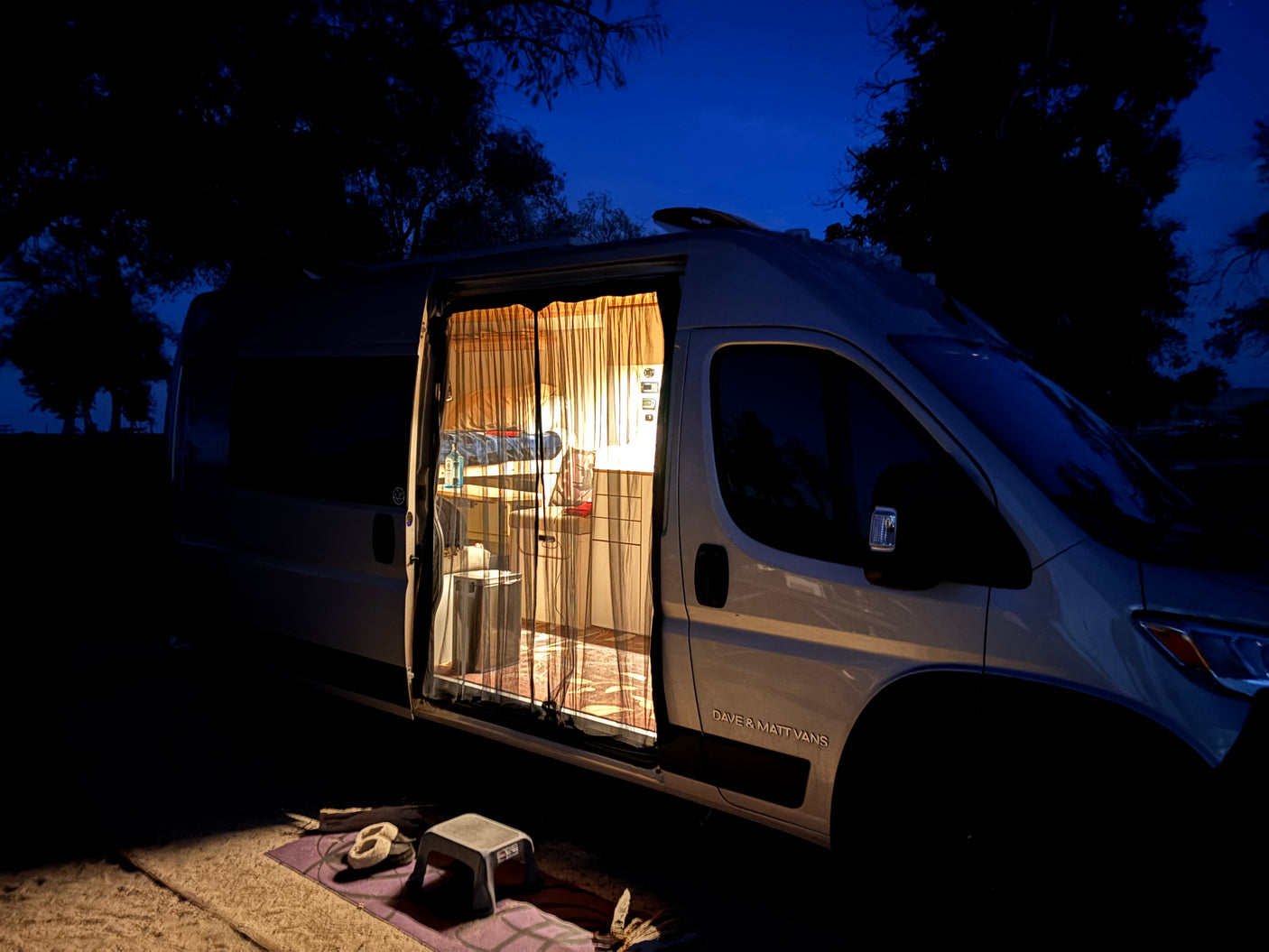 Cozy RV rental campervan at night with illuminated interior, perfect for camping adventures.