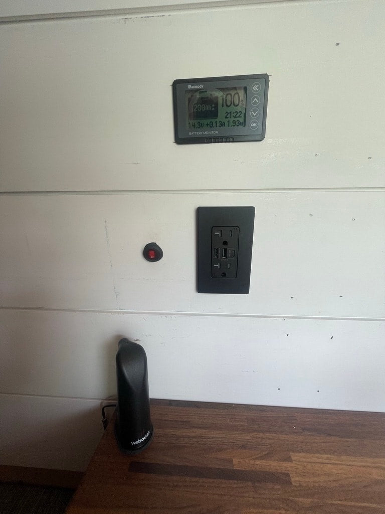 and white paneled walls.|Compact RV rental kitchen in a camper van