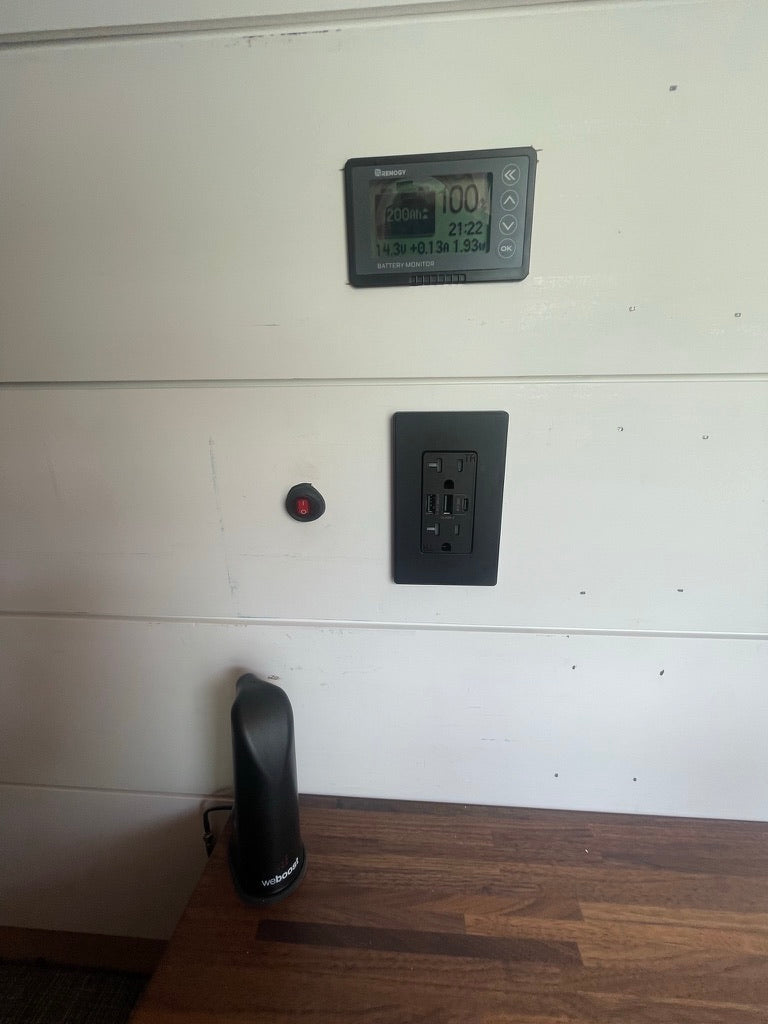 and white paneled walls.|Compact RV rental kitchen in a camper van