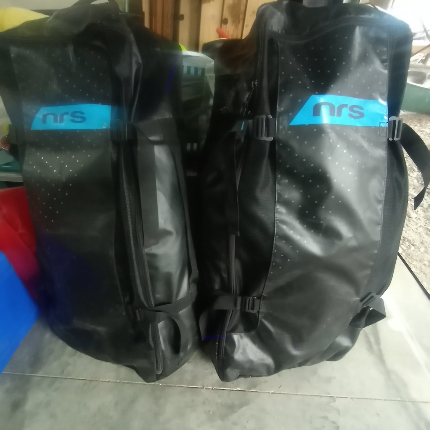 Two black NRS waterproof gear bags, ideal for storing essentials on your RV rental journey or any outdoor adventure.