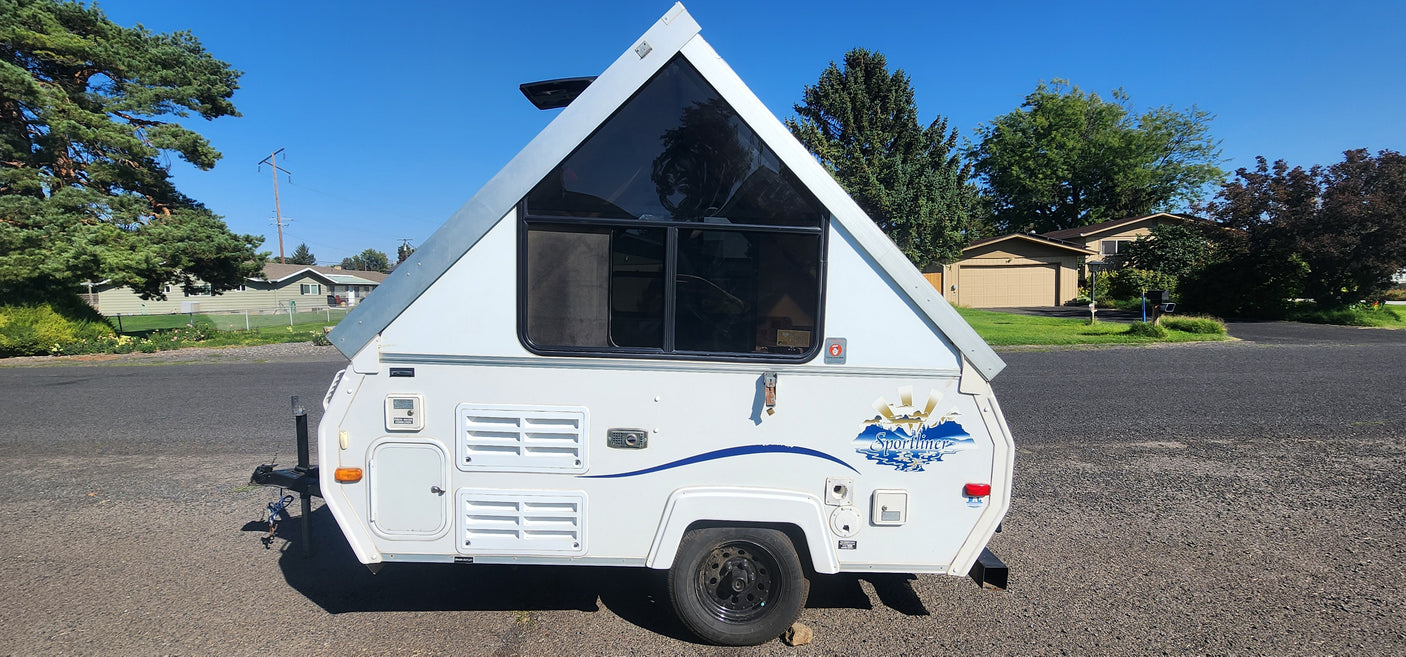 Compact A-frame rv rental, a white pop-up camper, ready for your next travel adventure and camping trip.