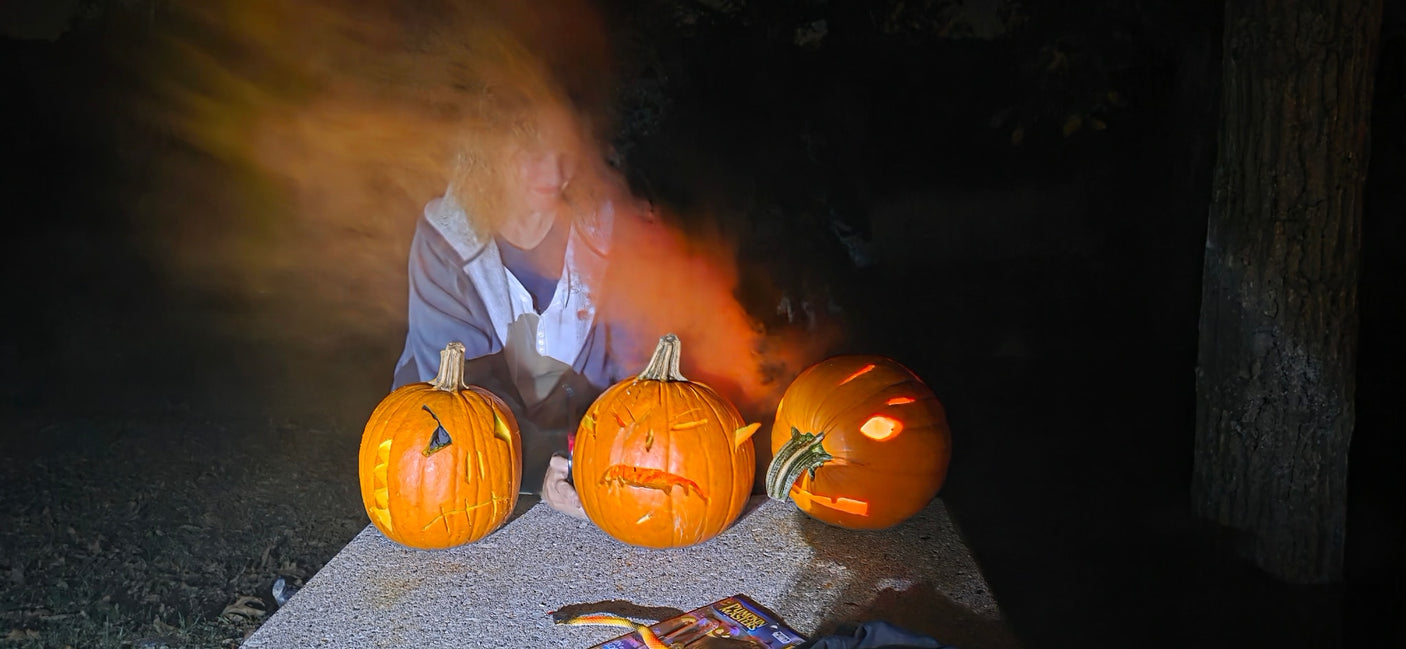 Ghostly figure and carved jack-o'-lanterns light up a spooky Halloween night scene. Ideal fun for your RV rental getaway.