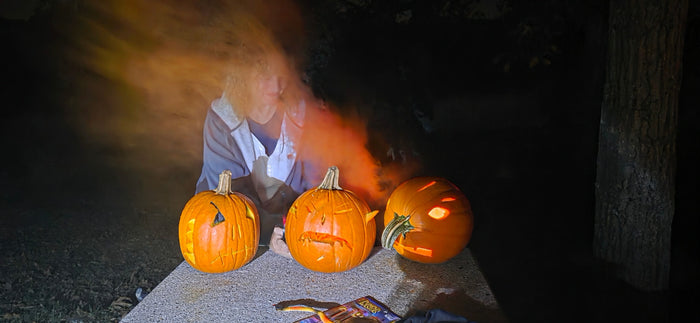 Ghostly figure and carved jack-o'-lanterns light up a spooky Halloween night scene. Ideal fun for your RV rental getaway.
