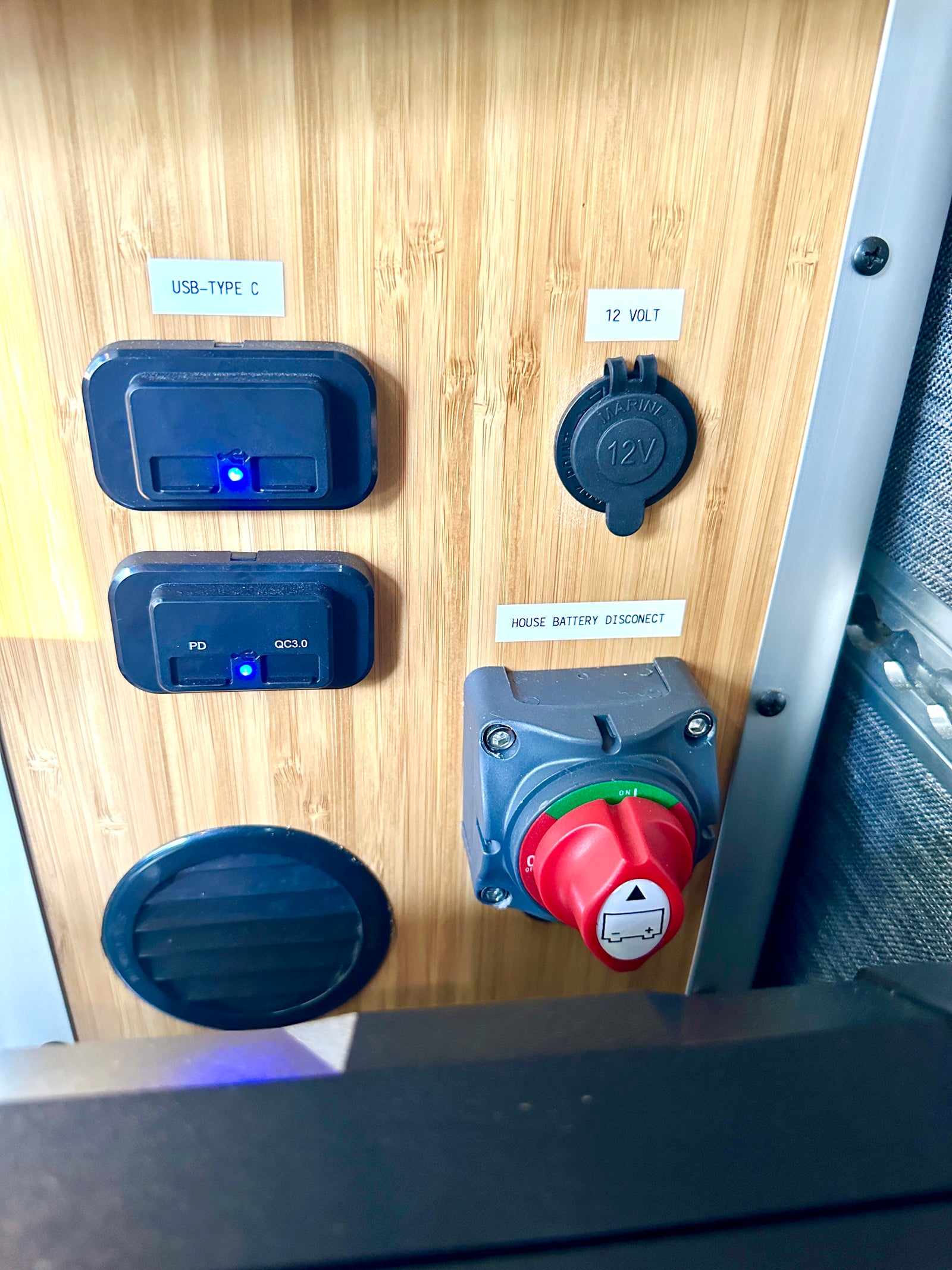 RV rental electrical panel featuring USB-C ports, 12-volt socket, and a house battery disconnect switch for onboard power control.