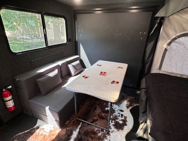 with "EXPLORE" text.|Spacious rv rental interior showing a large covered bed — photo 14